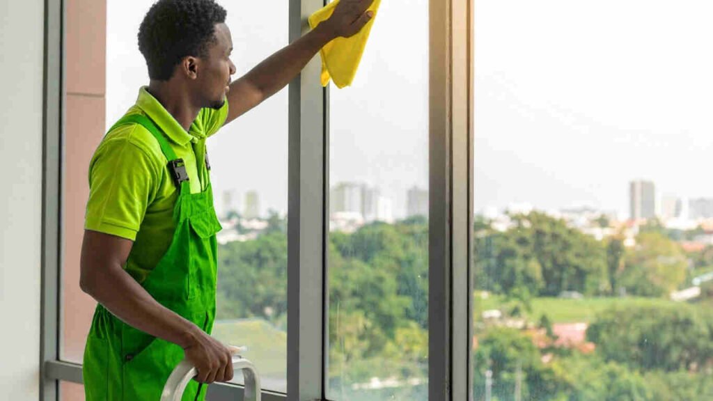 Professional team performing glass cleaning service for homes using eco-friendly tools in Abu Dhabi.